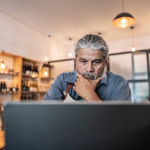 Worried business owner using laptop